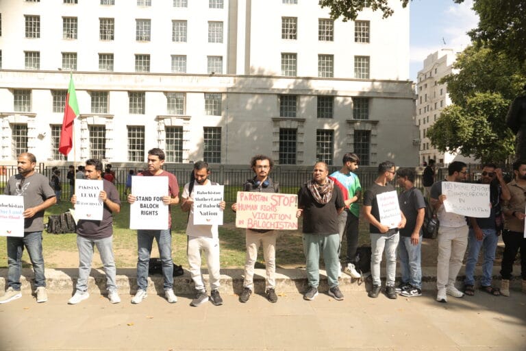 Aomar Karim holding placard “Pakistan Stop Human Rights Violations in Balochistan” at Pledge Renewal Day Rally, London, 2025.