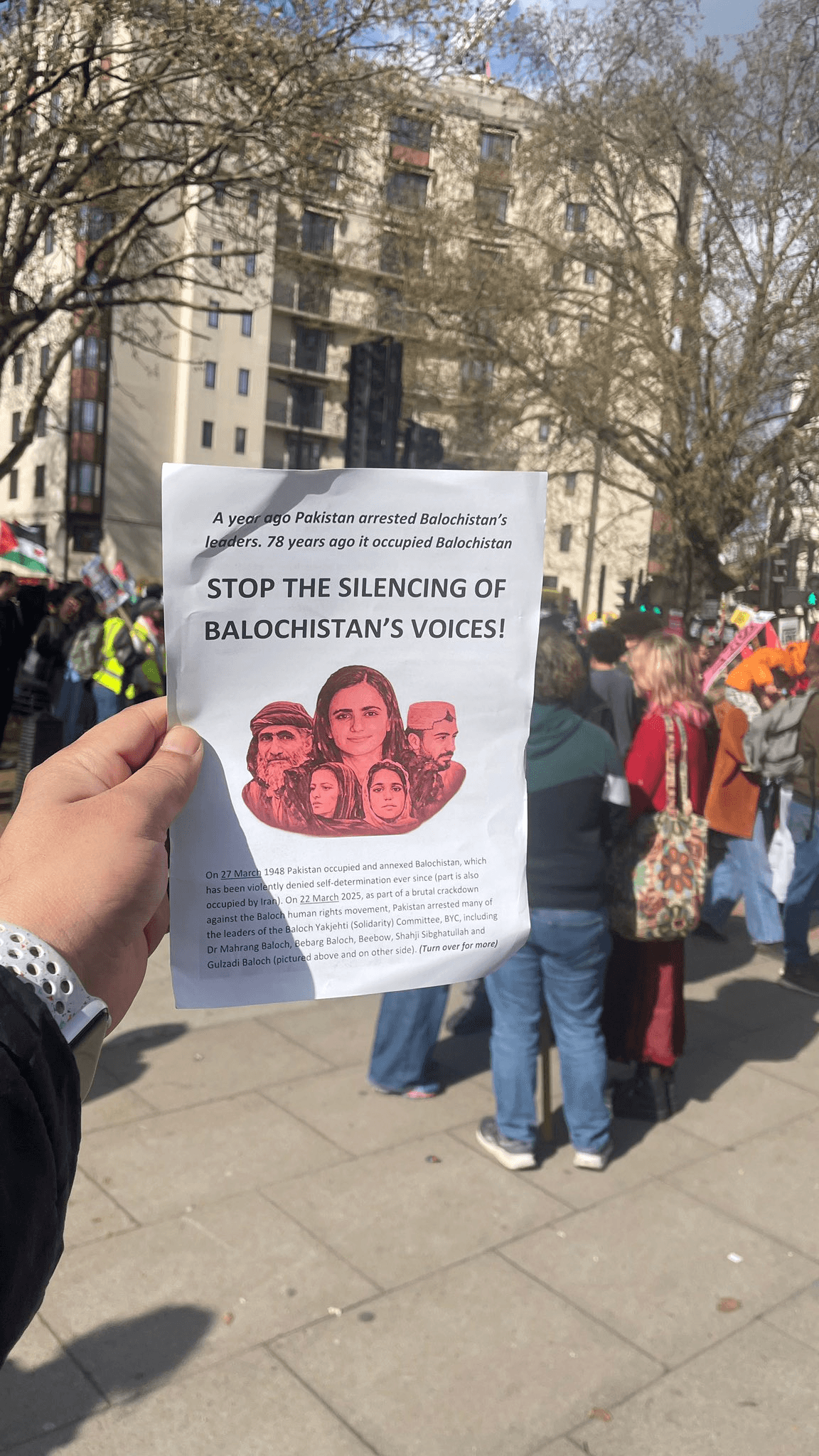 Disappeared, Killed, Silenced: Pakistan's Brutal Crackdown on Balochistan Exposed 3 Hand holding "Stop the Silencing of Balochistan's Voices" leaflet at London protest