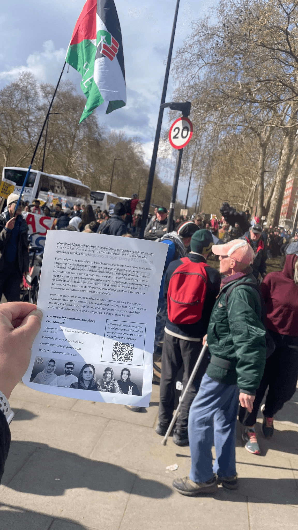 Disappeared, Killed, Silenced: Pakistan's Brutal Crackdown on Balochistan Exposed 4 Hand holding Balochistan solidarity leaflet at London demonstration with Palestinian flag in background